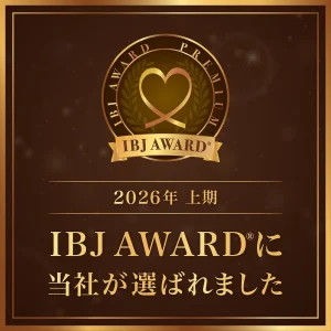 Gold-bound badge featuring a heart-shaped emblem and 'IBJ AWARD' ribbon, framed by a dark bronze panel—signifies an IBJ Award certificate.